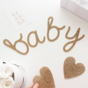Kaunis Baby -viiri vauvajuhliin, kultainen. Kimmeltävä glitterkultainen viiri, jossa on 2 sydäntä ja teksti "baby". Kirjaimet ja sydämet on valmistettu kestävästä akryylistä, eli ne ovat napakoita ja kestäviä. Settiin kuuluu kultainen 3 metriä pitkä nauha.
