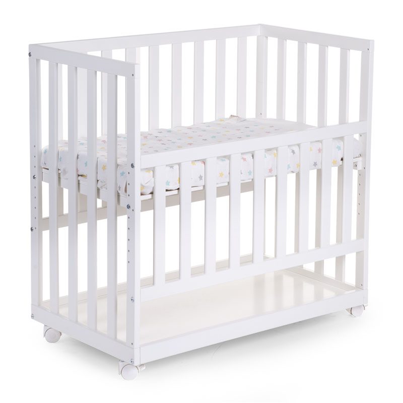 Childhome Bedside Crib Beech White puinen vauvan ensisänky renkailla. Nykyisin moni perhe toivoo, että vauva voisi nukkua ensimmäiset kuukaudet samassa huoneessa vanhempiensa kanssa. Kaikki eivät kuitenkaan tunne perhepetiä, jossa vauva nukkuu vanhempien välissä, sopivaksi ratkaisuksi. Childhome Bedside Crib on vanhempien sänkyyn kiinnittyvä vauvan ensisänky, josta laidan saa ylös, alas tai kokonaan pois. Vauva on siis helppo nostaa yöllä syömään tai rauhoittumaan äidin viereen, mutta vauvalla on silti oma turvallinen nukkumapaikkansa.