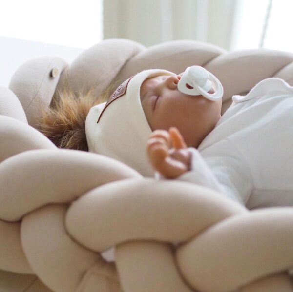 Kaunis palmikkoreunainen unipesä toimii pehmeänä alustana ja rauhoittavana nukkumapaikkana vauvalle. Voit laittaa unipesän ensin pinnasänkyyn ja luoda vastasyntyneelle pesämäisemmän nukkumapaikan, sillä sellaisenaan pinnasänky on aluksi valtavan kokoinen pienelle vauvalle. Moni pitää unipesää vanhempien sängyssä keskellä, jotta vauva on öisin lähellä, mutta kuitenkin vähän omassa rauhassaan. Tätä unipesää voit myös käyttää vaipanvaihtoalustana vaipanvaihtopisteellä.