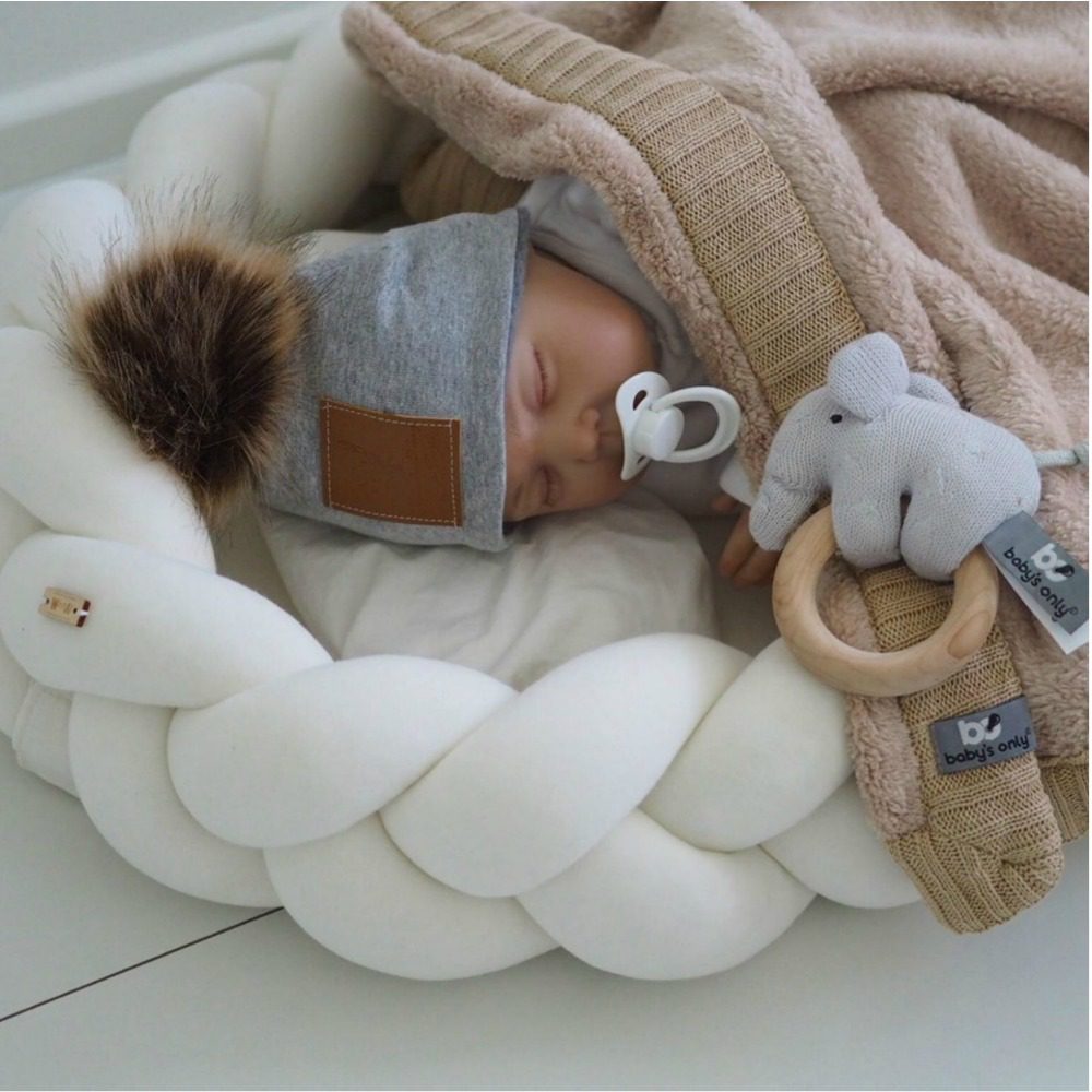 Wood'n'Wool vauvan unipesä, jossa irroitettavat reunat. Palmikkoreunan ansiosta unipesä on hyvin ilmava eli vauvan nukkumisympäristö pysyy raikkaana ja turvallisena koko unien ajan. Käytännöllistä on myöskin se, että palmikkoreunan saa helposti irti patjasta, eli palmikkoa voi käyttää vauvan sängyssä myöhemmin myös reunapehmusteena.