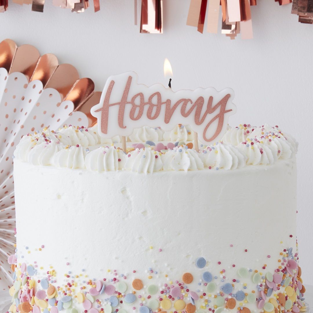Ginger Ray Hooray kakkukynttilä Tämä kaikkiin juhliin kauniisti sopiva kakkukynttilä näyttää upealta kakun päällä! Valkoisessa kynttilässä on "Hooray" -teksti ruusukultaisella värillä.