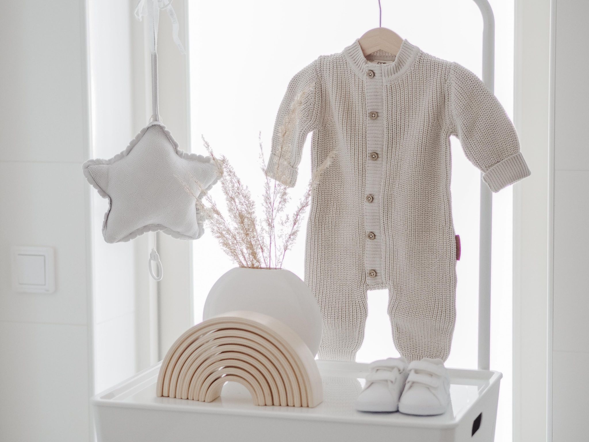 Baby’s Only Soul vauvan neulehaalari, sävy Warm Linen Tässä ajattoman kauniinsävyisessä neulehaalarissa on vetoketju, piilonepparikiinitys edessä ja päällä koristenapit. Vetoketju nopeuttaa pukemista. Hihoissa ja lahkeissa on resorit, jotka auttavat pitämään vauvan paremmin lämpöisenä ja lisäävät myös haalarin käyttöikää. Tämäntyyppinen neulehaalari on mukava vaate vauvalle, koska se ei purista mahan kohdalta, kuten jotkin housut ja vyötärönauhat saattavat tehdä. Vauva on myös helppo nostaa syliin kun hänellä on päällään neulehaalari: se ei nouse ikävästi kainaloihin tai jää ruttuun.