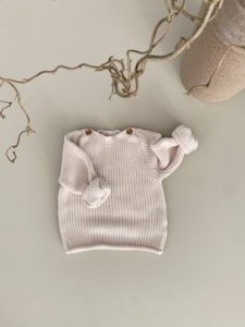 GUAPOO Button Knit Sweater neulepaita, Sandshell beige Rennon tyylikäs neulepaita, jossa on puiset napit kauniina yksityiskohtana. Pääntie on tarpeeksi leveä, jotta paita on helppo pukea päälle ja resorit hihoissa pidentävät vaatteen käyttöikää