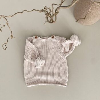 GUAPOO Button Knit Sweater neulepaita, Sandshell beige Rennon tyylikäs neulepaita, jossa on puiset napit kauniina yksityiskohtana. Pääntie on tarpeeksi leveä, jotta paita on helppo pukea päälle ja resorit hihoissa pidentävät vaatteen käyttöikää