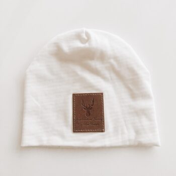 Pehmeä valkoinen trikoopipo, jossa edessä tekonahkainen logomerkki. Ihana syksyyn ja kevääseen!